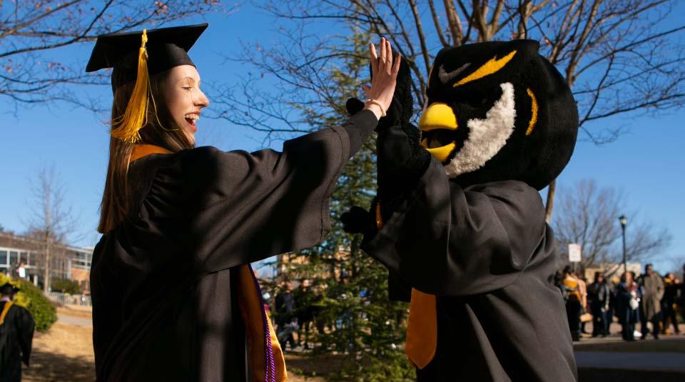 graduating student giving scrappy a high-five